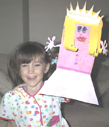 photo of the finished princess paper bag puppet held by a preschool girl